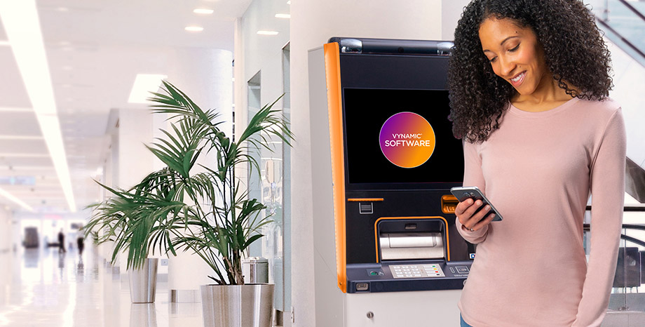 woman looking at phone in front of DN Series ATM