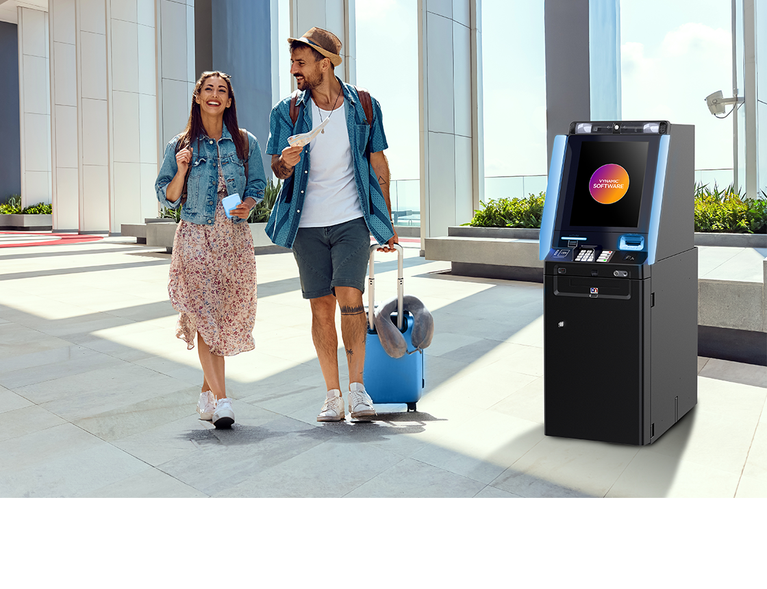 2 people walking by the DN Series® 300 Lobby ATM